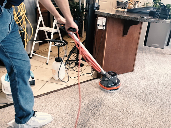 image of Kevin running the vacuum scrubber along by the kitchen